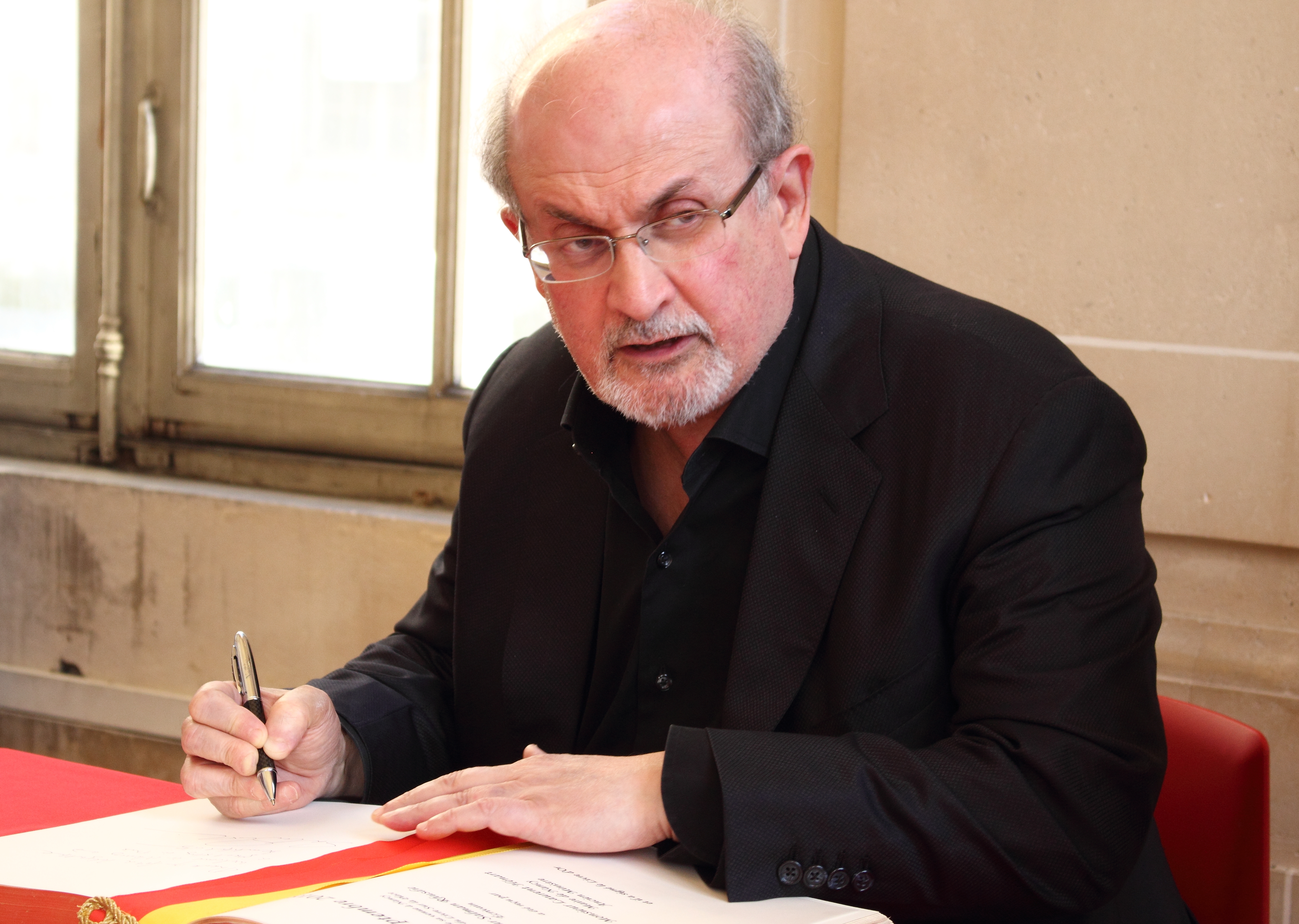 Salman Rushdie signing a book